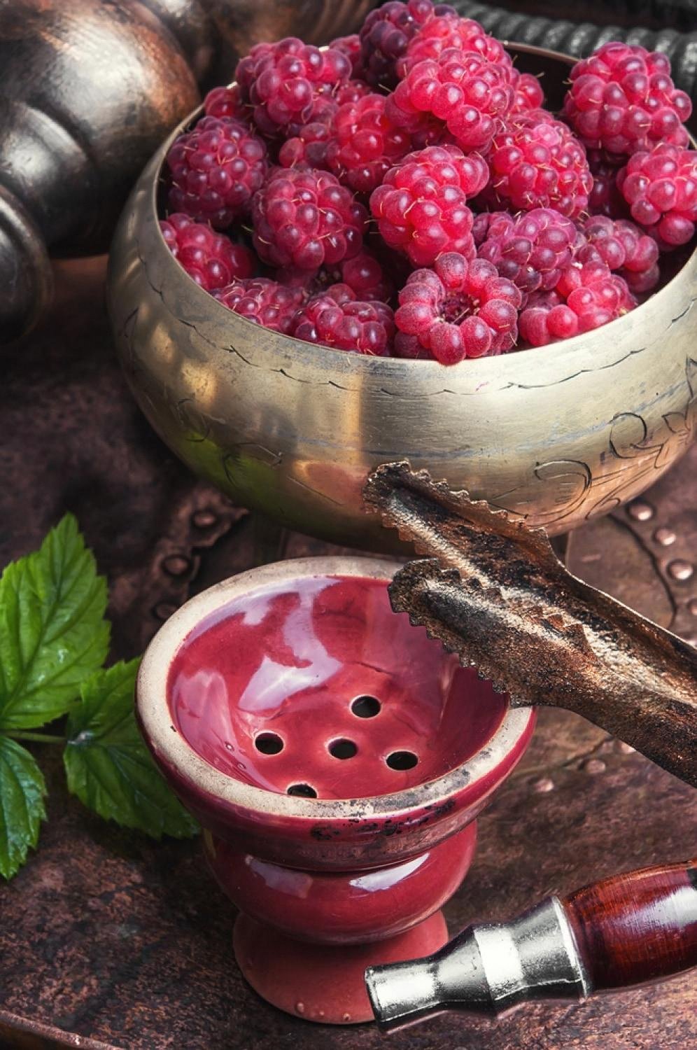 Bowl of raspberries next to a shisha bowl representing berry vape flavour development